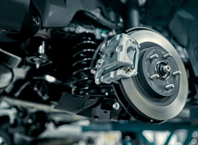 Disc brake of the vehicle for repair, in process of new tire replacement. Car brake repairing in garage.Suspension of car for maintenance brakes and shock absorber systems.Close up.