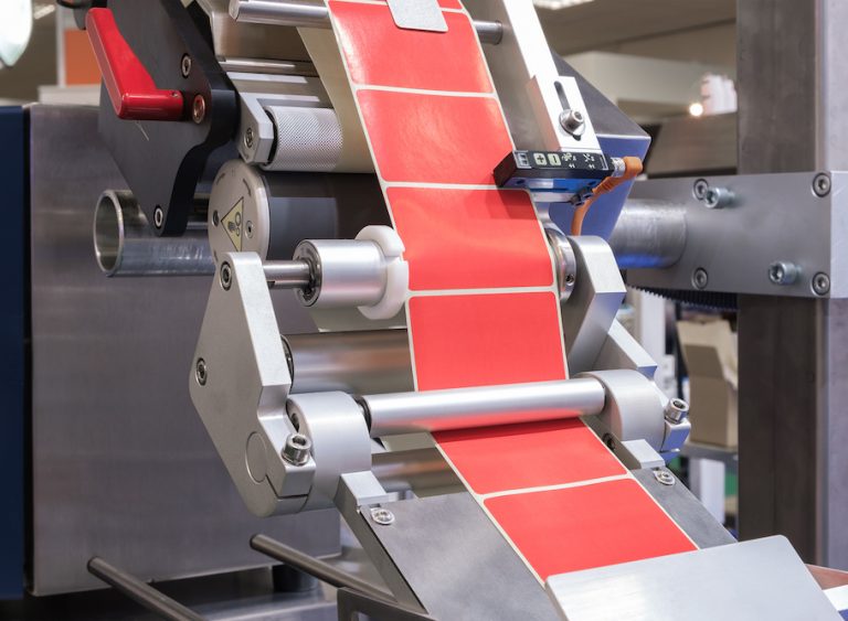 Fragment of the conveyor of the pharmaceutical labeling machine. Abstract industrial background.